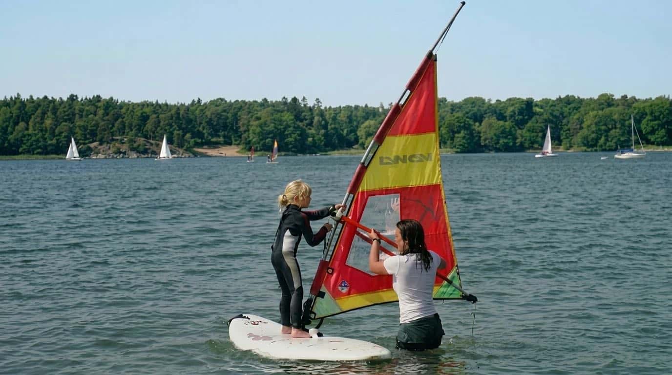 Kind beim ersten Aufholen des Segels im Kinder-Surfkurs am Müggelsee